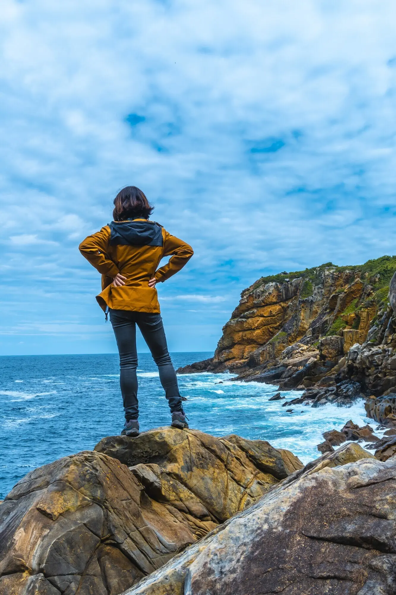Ein weibliches Model blickt zufrieden auf das schöne Meer.
